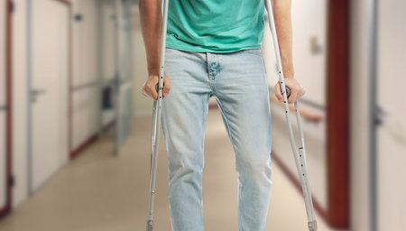 Man with axillary crutches in hospital, closeup. Banner design