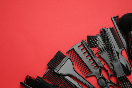 Different hairdresser's tools on red background, flat lay. Space for textの写真素材