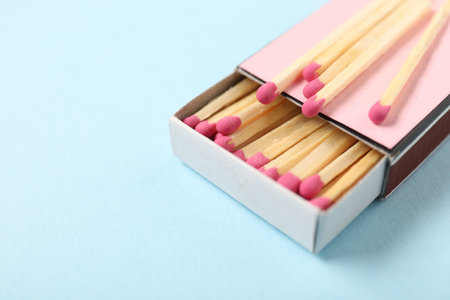 Matches and box on light blue background, closeup. Space for textの写真素材