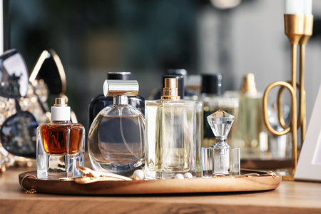 Bottles of different perfumes and accessories on wooden table, closeupの写真素材