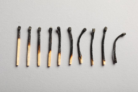Burnt matches on grey background, flat layの写真素材