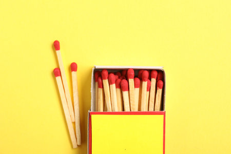 Matches and box on yellow background, flat lay. Mockup for designの写真素材