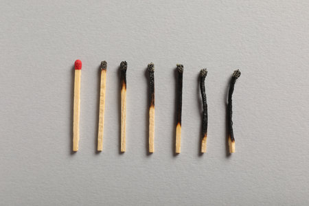 Burnt and whole matches on grey background, flat layの写真素材