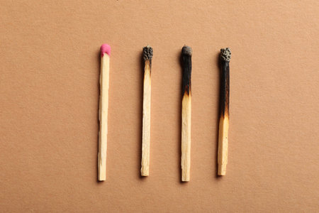 Burnt and whole matches on beige background, flat layの写真素材