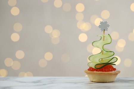 Tasty canape on white marble table against background with blurred lights, space for text. Bokeh effectの写真素材