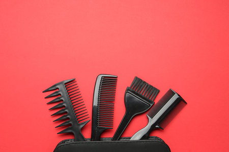 Different hairdresser's tools and case on red background, flat lay. Space for textの写真素材