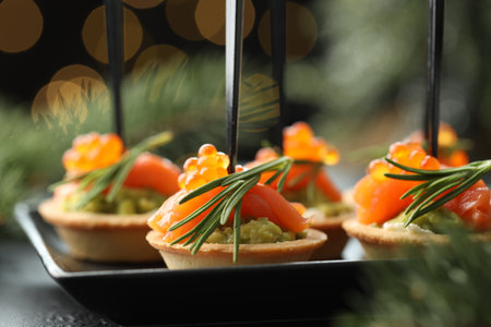 Tasty canapes and Christmas decor on table, closeup. Bokeh effectの写真素材