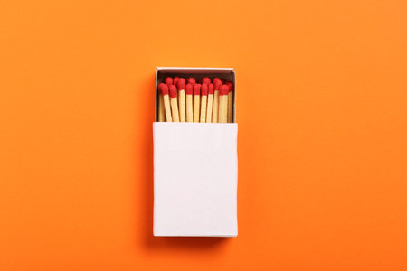Matches in box on orange background, top view. Mockup for designの写真素材