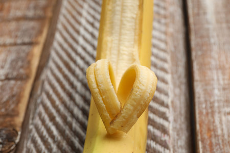 Banana with heart made of peel on wooden table, closeupの写真素材