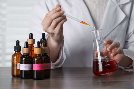 Professional perfumer developing luxury perfume at wooden table in laboratory, closeupの写真素材