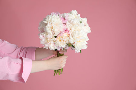 Woman with bouquet of beautiful peonies on pink background, closeup. Space for textの写真素材