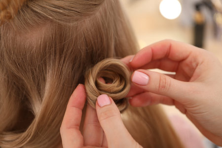 Hairdresser styling woman's hair in salon, closeupの写真素材
