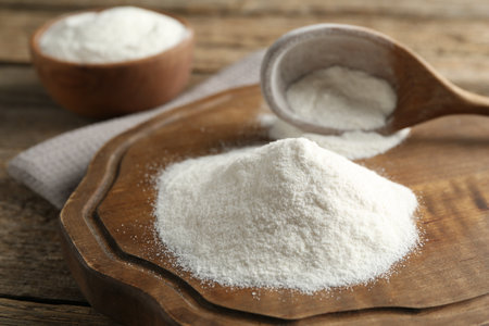Wheat flour and spoon on wooden table, closeupの写真素材