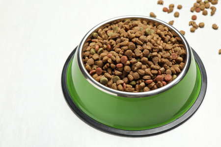 Dry pet food in feeding bowl on light background, closeupの写真素材