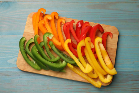 Cut colorful bell peppers on blue wooden table, top viewの写真素材