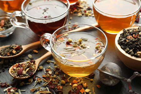 Different herbal teas and dry leaves on black table, closeupの写真素材