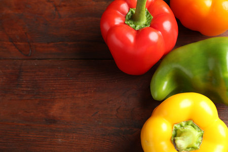Ripe colorful bell peppers on wooden table, closeup. Space for textの写真素材