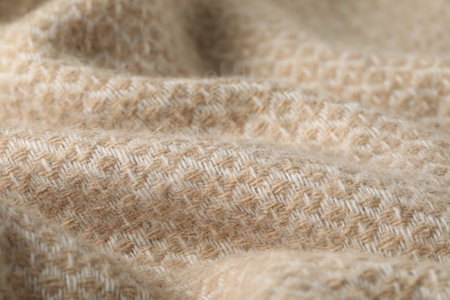 Texture of beige wool fabric as background, closeup