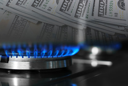 Gas burner with blue flame and dollar bills, double exposure. Gas tariffの写真素材