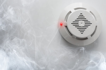 Fire alarm system. Detector on ceiling triggered by smoke, bottom viewの写真素材