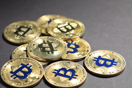Cryptocurrency. Golden bitcoins on grey background, closeup