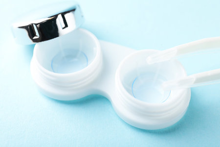 Contact lenses in case and tweezers on light blue background, closeupの写真素材