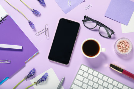 Flat lay composition with stationery, phone, coffee and flowers on violet backgroundの写真素材