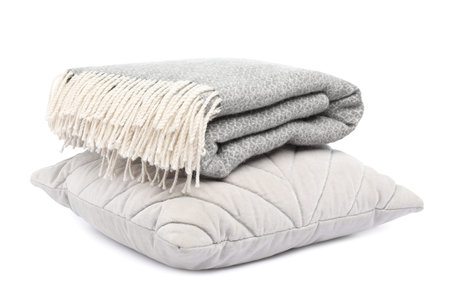 Folded woolen blanket and pillow isolated on whiteの写真素材