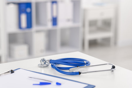 Doctor's workplace with stethoscope and paperwork on desk, closeup. Space for textの写真素材