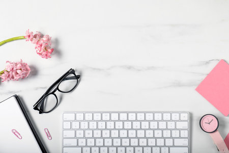 Flat lay composition with stationery and flowers on white marble table. Space for textの写真素材