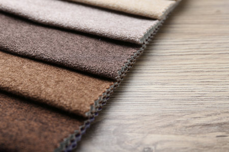 Samples of different fabrics on wooden table, closeup. Space for textの写真素材