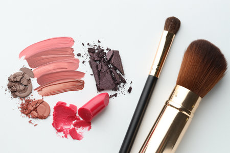 Different cosmetic products and makeup brushes on white background, flat layの写真素材