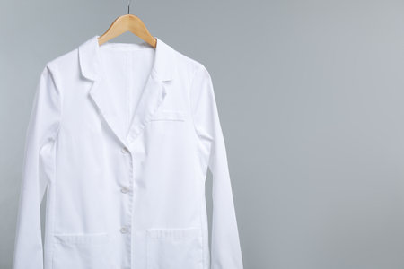 Doctor's coat on hanger against grey background. Space for textの写真素材