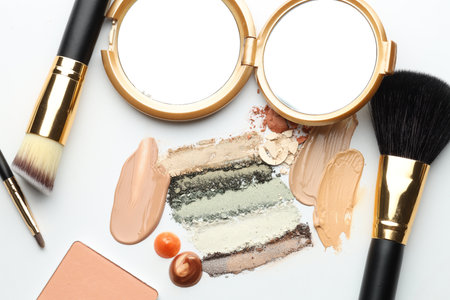 Different cosmetic products, makeup brushes and mirror on white background, flat layの写真素材