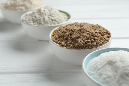 Different types of flour in bowls on white wooden table, closeupの写真素材