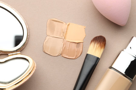 Colorful skin foundations and makeup brush on grey background, flat layの写真素材