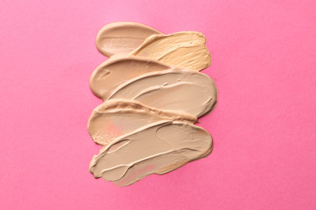 Colorful skin foundations on magenta background, above viewの写真素材