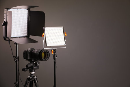 Professional lighting equipment and camera on grey background. Space for textの写真素材