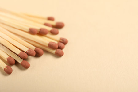 Matches with brown heads on beige background, closeup. Space for textの写真素材