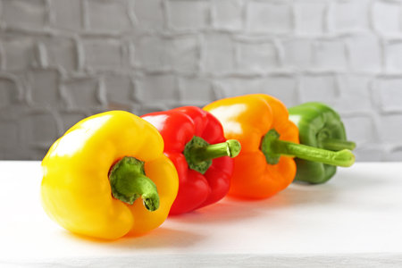 Ripe colorful bell peppers on white tableの写真素材