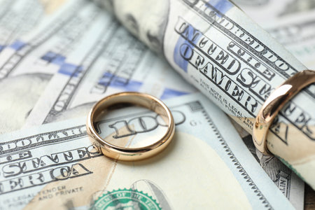 Gold wedding rings and dollar banknotes, closeupの写真素材