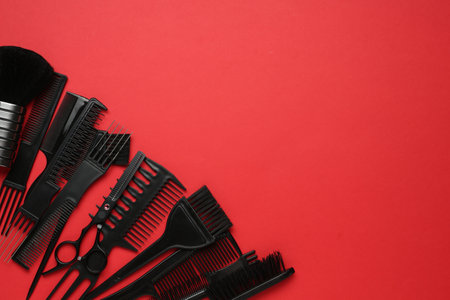 Different hairdresser's tools on red background, flat lay. Space for textの写真素材