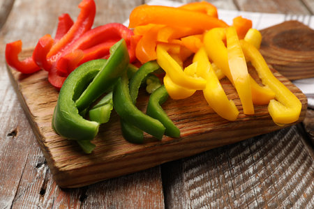Cut colorful bell peppers on wooden table, closeupの写真素材