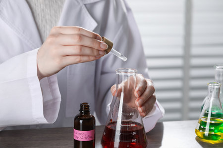 Professional perfumer developing luxury perfume at wooden table in laboratory, closeupの写真素材