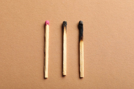 Burnt and whole matches on beige background, flat layの写真素材