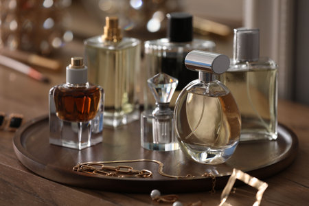 Bottles of different perfumes and accessories on wooden table, closeupの写真素材