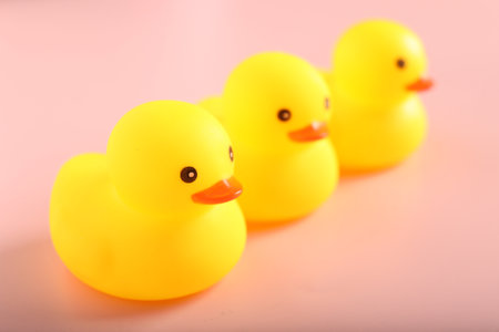 Three cute rubber ducks on pink background, closeupの写真素材