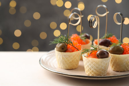 Tasty canapes on white table against blurred lights, closeup. Space for textの写真素材