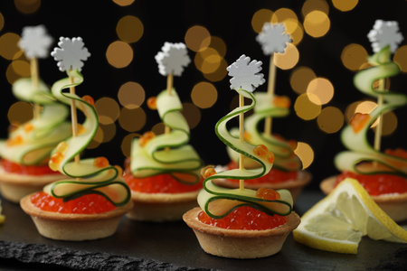 Tasty canapes on table against dark background with blurred lights, closeup. Bokeh effectの写真素材