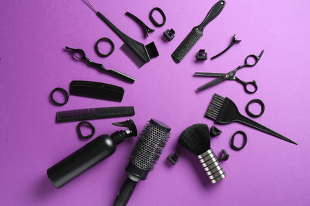 Frame of different hairdresser's tools on violet background, flat lay. Space for textの写真素材